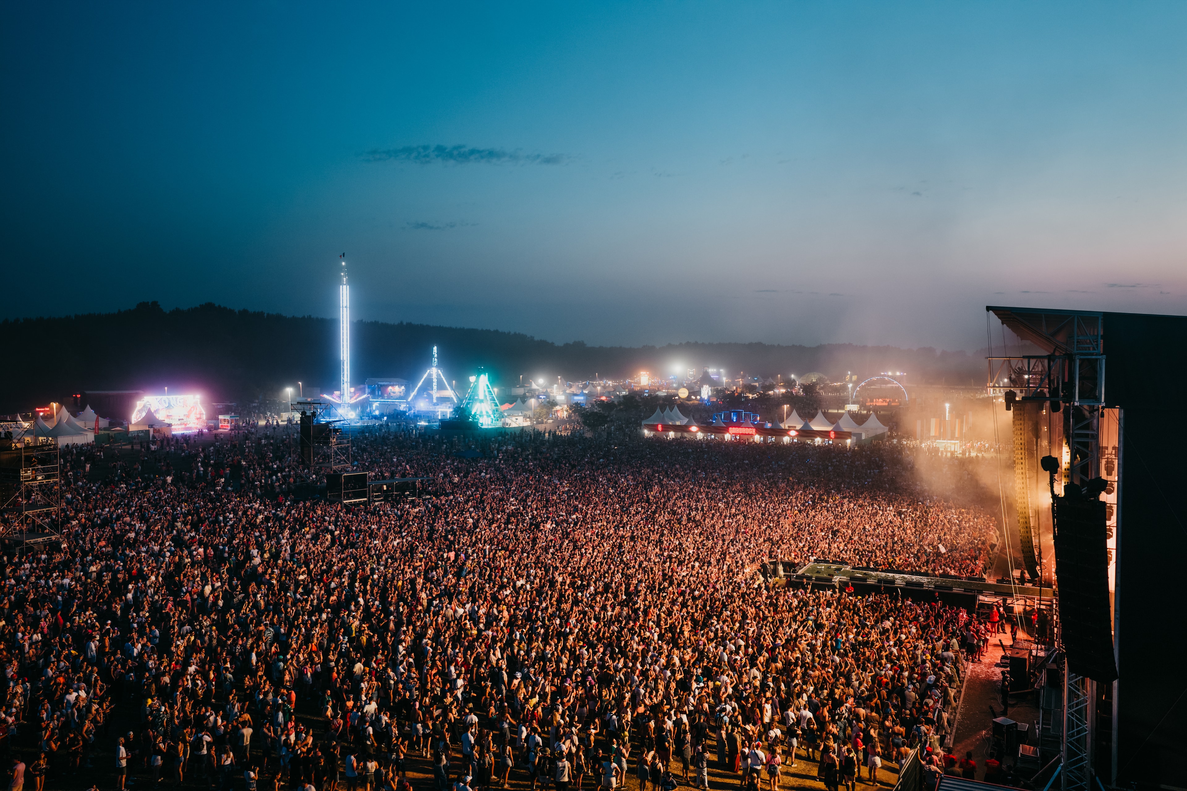 Vue aérienne au drone d'un festival de nuit, foule immense sous les lumières